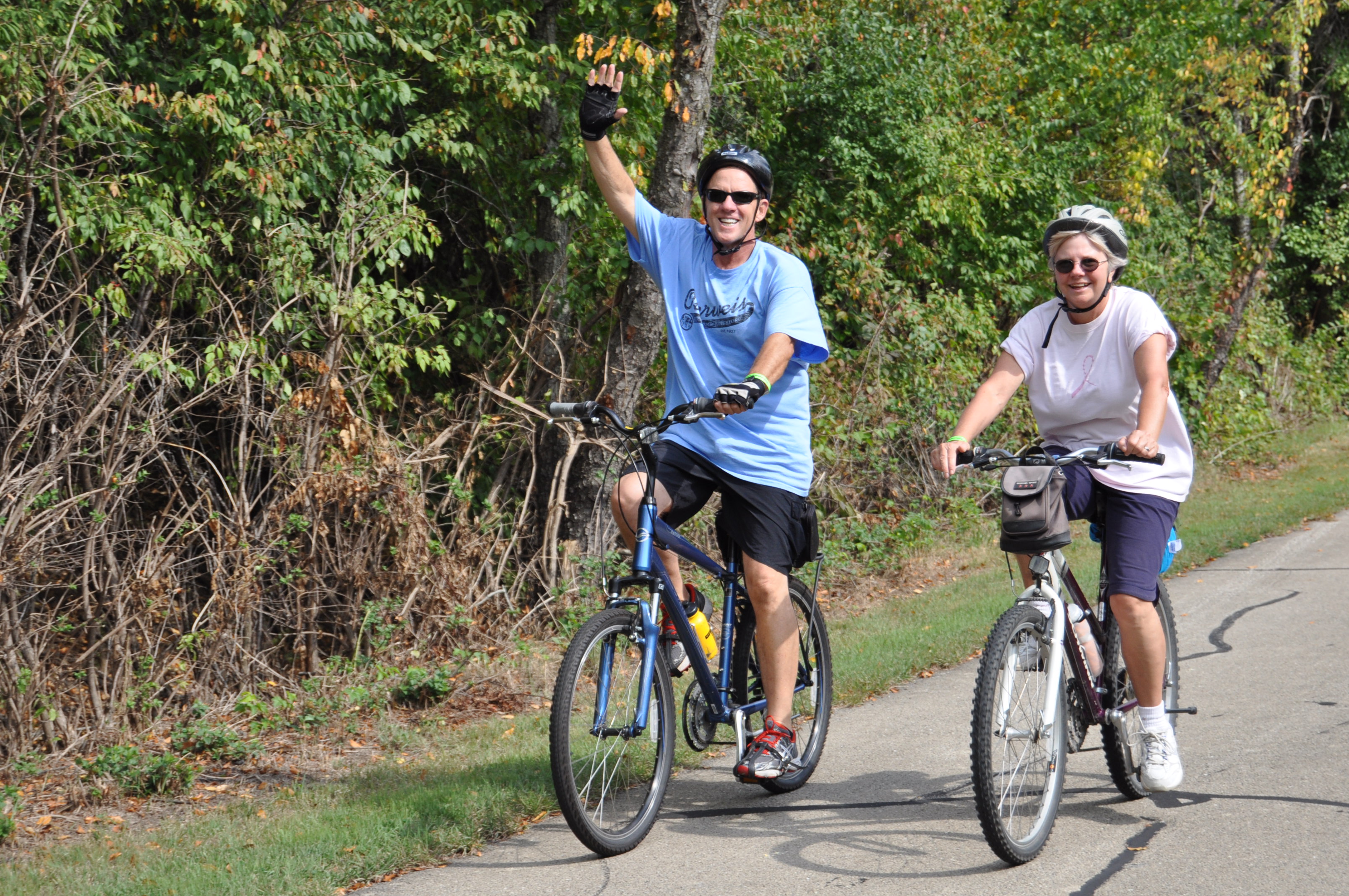a man and woman biking on a trail